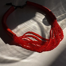 Load image into Gallery viewer, A choker that pairs hand-stitched leather with cascading strands of glass beads. The tubular leather form gives it presence, while the beads add fluid movement in a striking red. Lightweight and adjustable, made for moments that stand out.