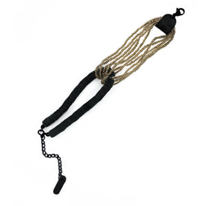 Handcrafted bracelet with golden glass beads interlocked with black leather disks and adjustable chain.
