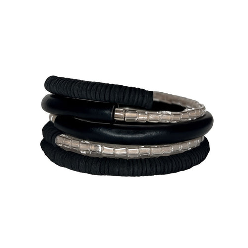 Black leather coil bracelet made from punched disks and stitched leather tube, with blush pink shiny glass beads

