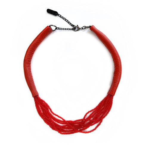 A choker that pairs hand-stitched leather with cascading strands of glass beads. The tubular leather form gives it presence, while the beads add fluid movement in a striking red. Lightweight and adjustable, made for moments that stand out.