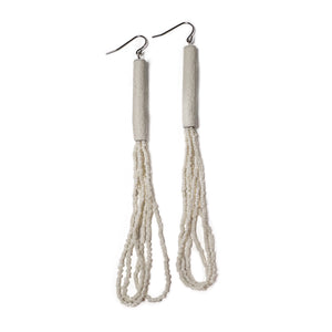 A pair of handcrafted earrings with ivory leather cylindrical tops, cascading strands of white glass seed beads, and hypoallergenic stainless steel hooks.