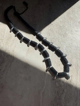 Load image into Gallery viewer, Metallic object with springs on a textured surface