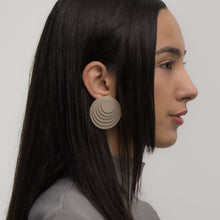 Load image into Gallery viewer, A pair of taupe layered leather earrings with concentric circular designs, handcrafted for a bold and dimensional look.