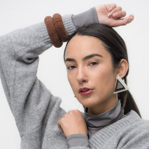 Handcrafted bracelet made from upcycled leather in a rich brown tone, featuring a sculptural and layered design with a unique spiral form.