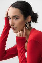 Load image into Gallery viewer, Close-up of snake-inspired earrings made from black, beige, and white leather. The layered design resembles scales, featuring a bold mosaic pattern with a textured, modern look. Handcrafted from upcycled leather, they are lightweight and sustainable.