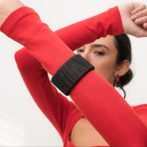 A handcrafted black leather cuff bracelet featuring a ridged texture and a minimal design