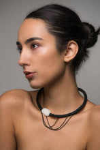 Load image into Gallery viewer, A handcrafted choker featuring a smooth white jade stone, stainless steel chains draping elegantly, a hand-stitched leather tube on one side, and individually hand-punched leather discs on the other. This bold and modern design combines texture and craftsmanship for a striking statement piece.