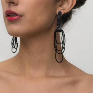 Pair of Noir Cascade earrings featuring black Japanese glass beads cascading in layered strands, combined with soft black leather accents for a bold and elegant look.