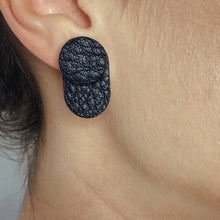Load image into Gallery viewer, A person wearing the upcycled leather earrings with the black side of the double-sided second part facing forward for a bold and edgy style.