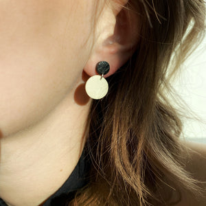 Effortlessly chic minimalist earrings in earthy tones. Basic shapes & delicate leather grain add subtle character. Suspended circles symbolize wholeness & promote a state of calm. Perfect for modernizing any outfit.