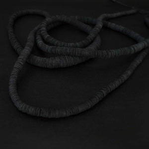 Elevate your style with our bold and modern extra-long necklace. Crafted with genuine leather disks ranging from 6-14mm and cotton waxed cord, it's a true statement piece that challenges the ideals of traditional accessories. Wear it as is or get creative by draping it around your waist or creating a crossed pattern. This disruptor of a necklace is sure to turn heads and start conversations. Shop now for a minimalistic yet eye-catching addition to your high-fashion wardrobe.