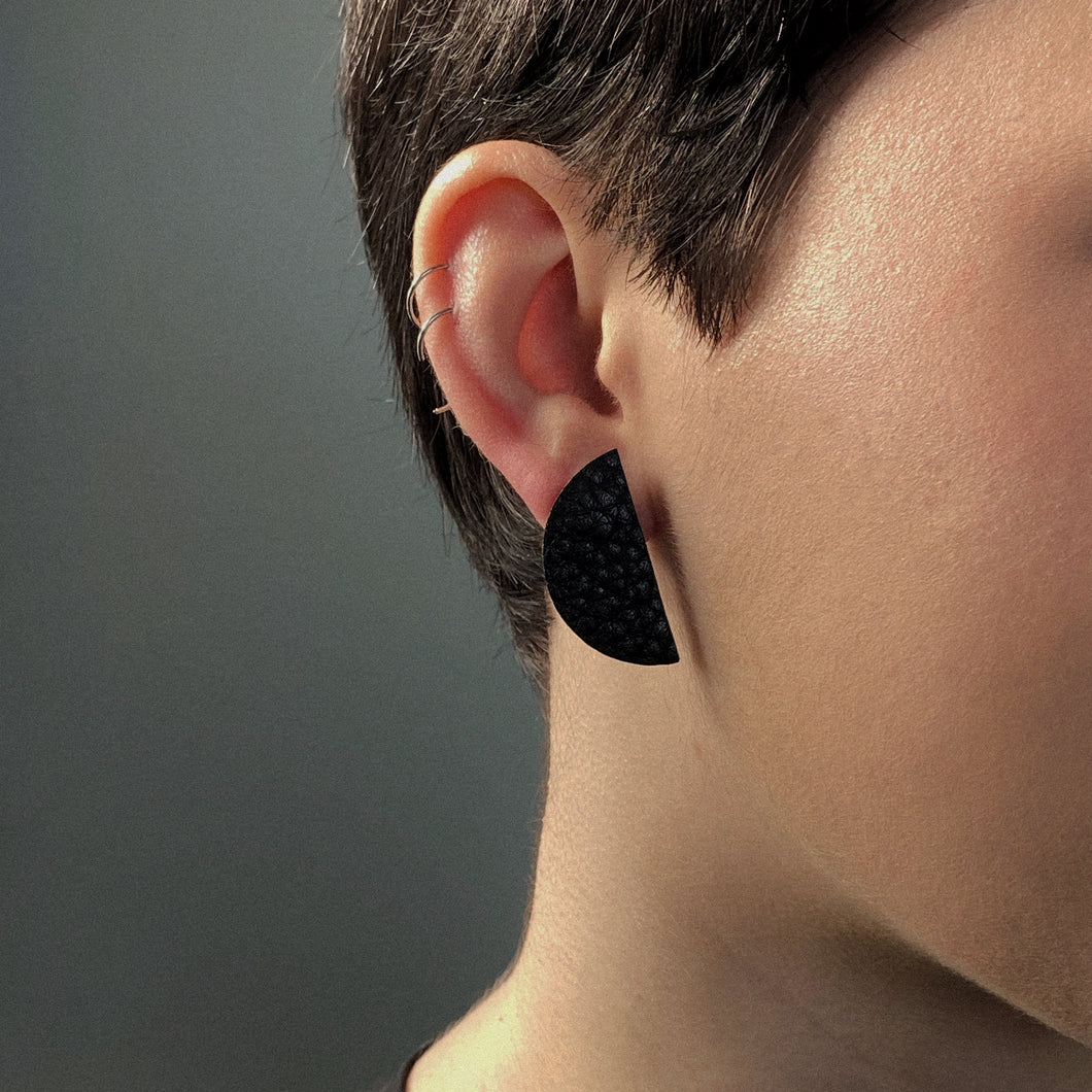 Upgrade your basic stud game with our leather studs that speak louder than words. These earrings add a touch of personality to any monochrome outfit and tie your look together phenomenally. The semicircle's bold yet simple shape, combined with the softest texture, exudes modern sophistication. The two pieces together represent wholeness, just like you. Don't miss out on these statement earrings that showcase your uniqueness. Shop now for a pair of earrings that complete your look