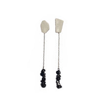 Load image into Gallery viewer, Elevate your style with our contemporary drop earrings. The asymmetrical form and contrasting elements add a modern edge, while luxurious textured leather and hematite provide sophistication and a touch of mystery. Hematite promotes calmness, strength, stability, and protection. With a carefree swing, these earrings allow you to stride tall and restore your equilibrium. Shop now for a statement piece that combines modern elegance with natural healing properties