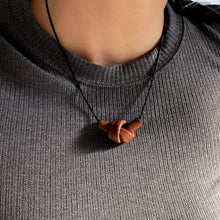 Load image into Gallery viewer, Elevate your style with a leather knot pendant necklace - a symbol of eternal connection and cherished bonds. With modern sophistication and impeccable hand craftsmanship, this necklace showcases the fine qualities of leather. Available in two lengths, it&#39;s functional art with a meaning, making it the perfect gift for yourself or a loved one. Choose the shorter length for a flattering collarbone accent or the longer length to wear over your heart.