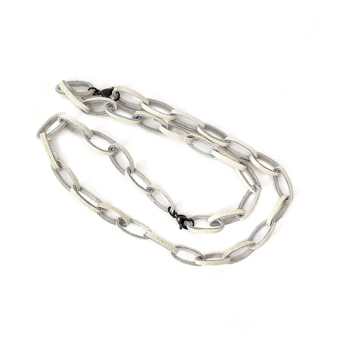 Elevate your jewelry collection with this unique hand-stitched leather chain from WAIWAI. The innovative design features leather links and strategically-placed clasps, allowing for multiple styling options. The soft texture and visible grain of the high-quality leather make for a luxurious and comfortable wear. Lightweight and versatile, this chain adds a powerful sense of connectedness to any outfit.