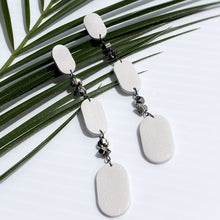 Load image into Gallery viewer, Looking for a bold and empowering accessory? Look no further than these crisp white leather and pyrite earrings. The raw metallic lustre of pyrite adds a touch of mystery and provides protection from negative energy while promoting physical healing and emotional strength. Perfect for any occasion, these earrings embody the harmonized contrasts of life and empower you to feel radiant and serene like a modern goddess.