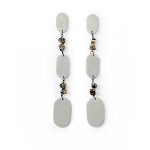 Looking for a bold and empowering accessory? Look no further than these crisp white leather and pyrite earrings. The raw metallic lustre of pyrite adds a touch of mystery and provides protection from negative energy while promoting physical healing and emotional strength. Perfect for any occasion, these earrings embody the harmonized contrasts of life and empower you to feel radiant and serene like a modern goddess.